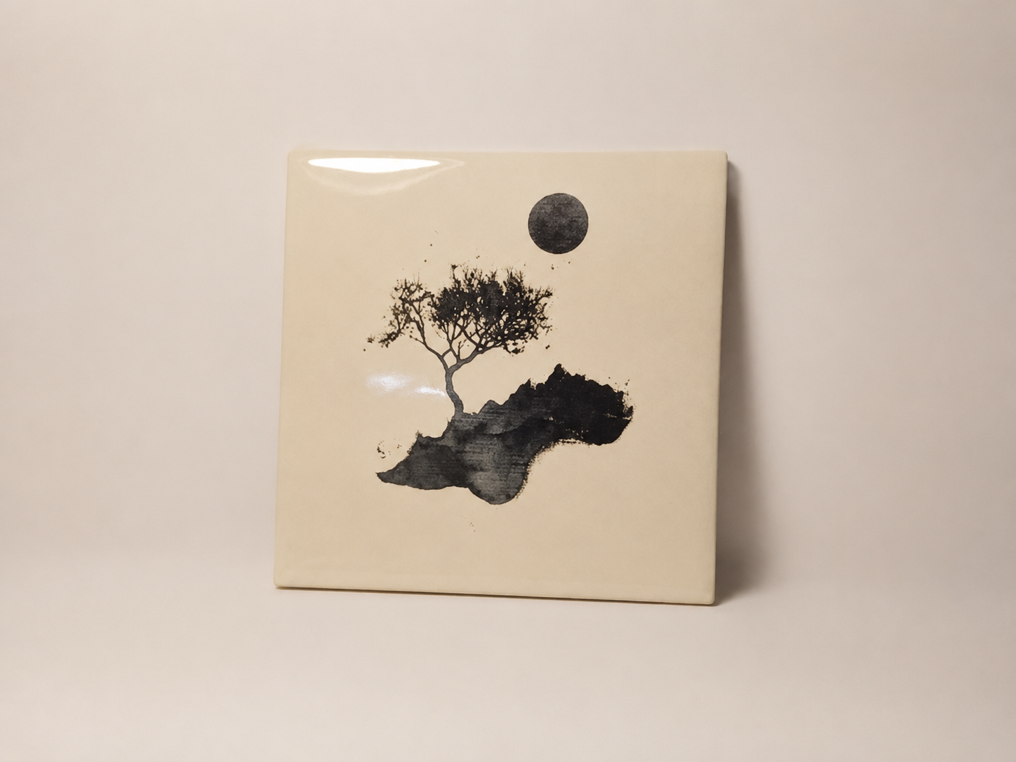 Cream ceramic tile with a lone tree on a rocky island under a dark moon