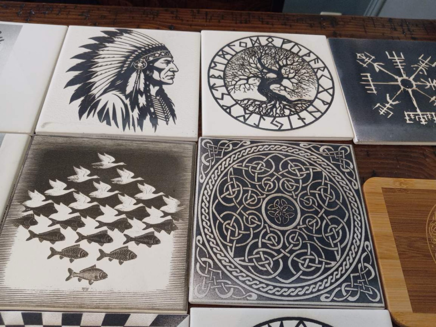 Collection of engraved tiles including Native American portrait, Tree of Life with runes, birds and fish, and Celtic knotwork